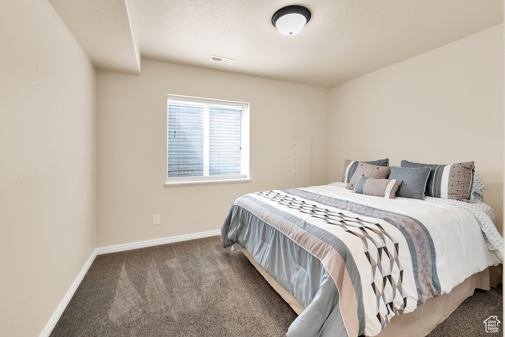 Bedroom with visible vents, carpet, and baseboards