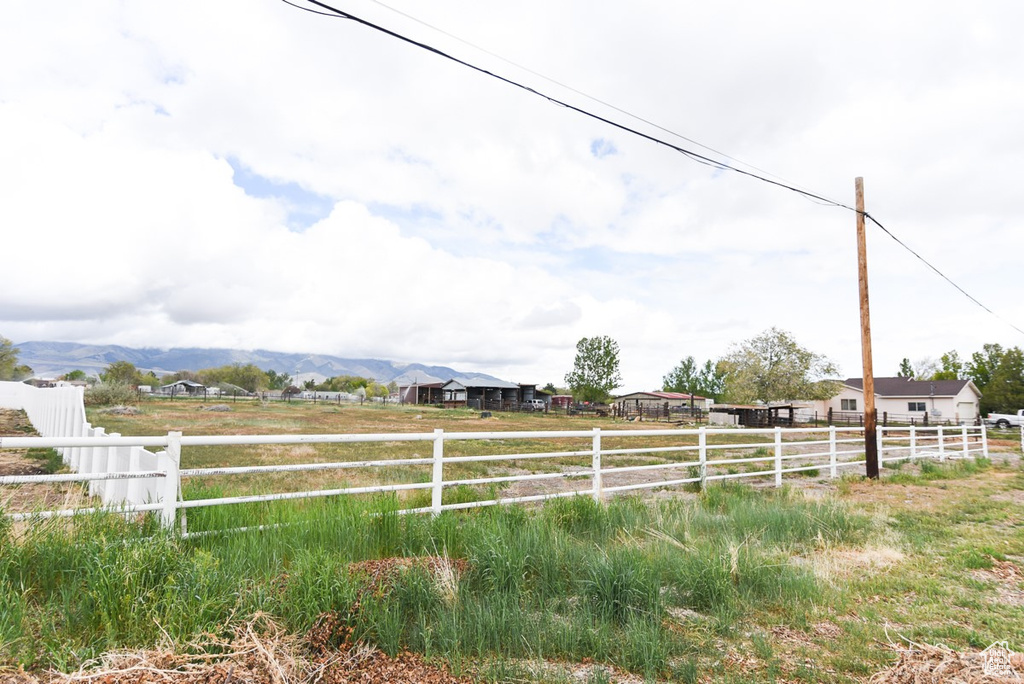 View of yard featuring a mountain view, fence, and a rural view