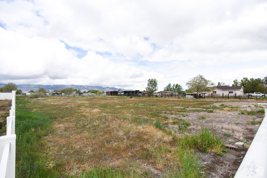 View of yard with a mountain view and fence
