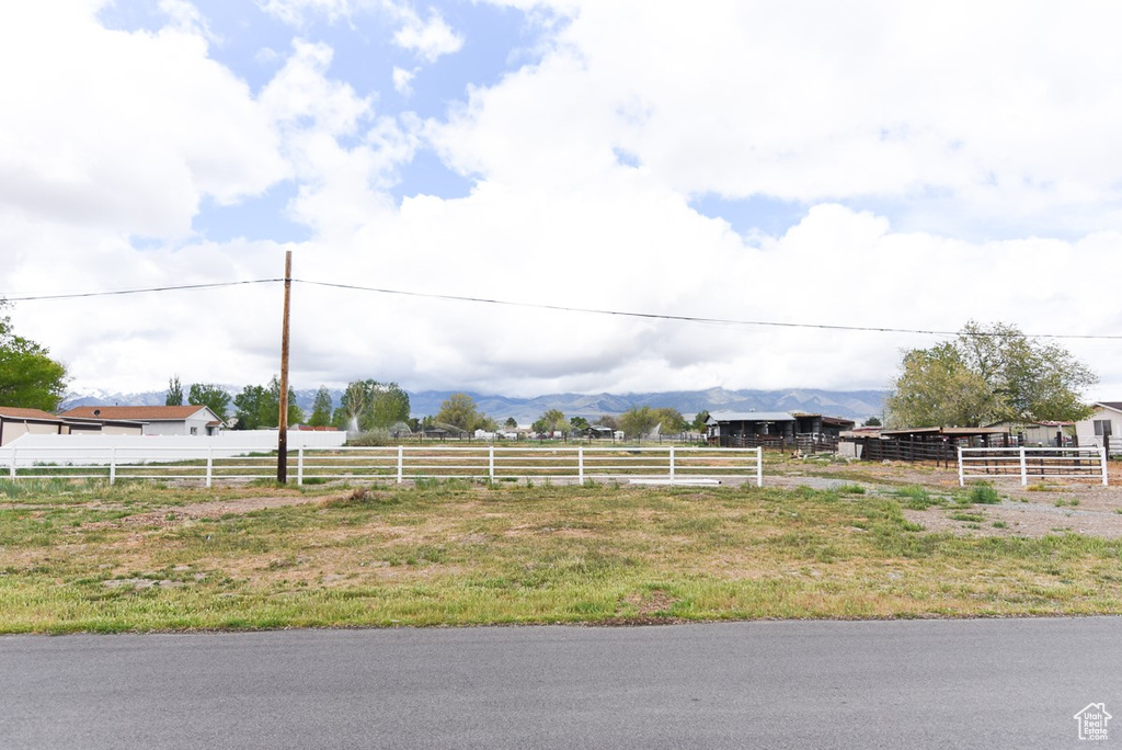 View of yard with fence, a mountain view, and a rural view