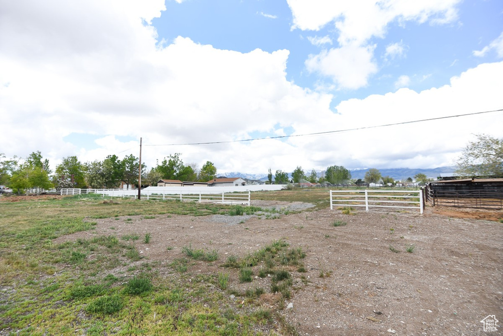 View of yard with fence and a rural view