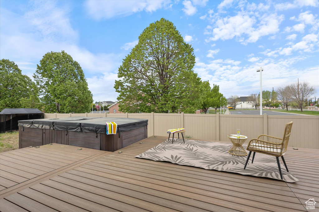 Deck with a hot tub and fence