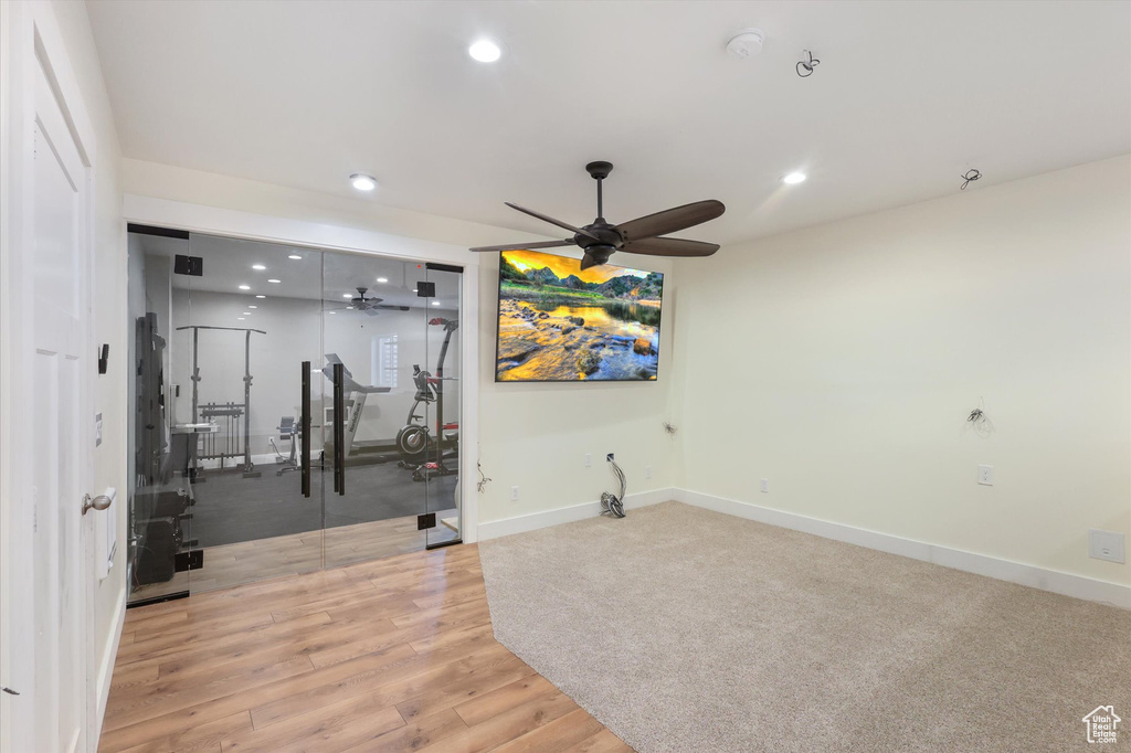 Workout room with baseboards, light wood-type flooring, a ceiling fan, and recessed lighting