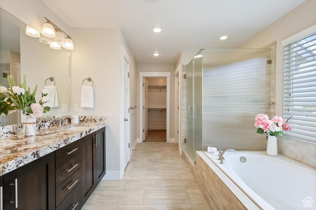 Bathroom with vanity, recessed lighting, a walk in closet, and a stall shower