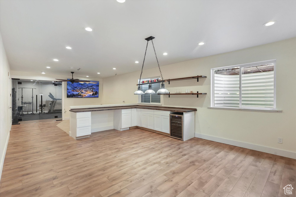 Kitchen featuring light wood-style floors, recessed lighting, baseboards, and wine cooler