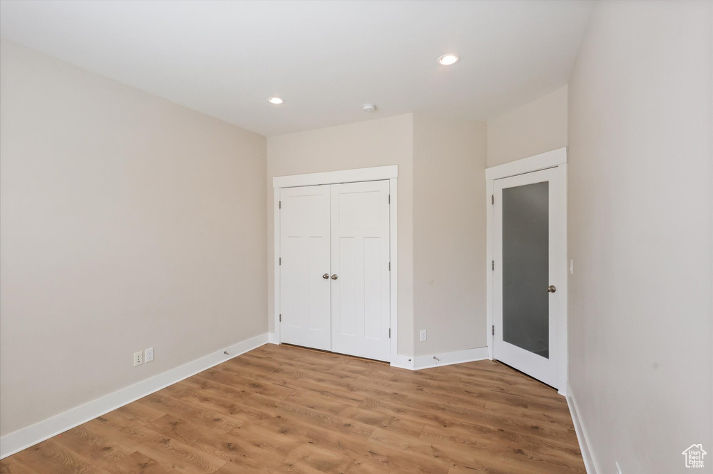Unfurnished bedroom with light wood-style floors, recessed lighting, baseboards, and a closet