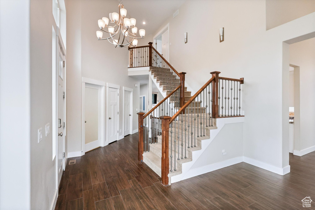 Entryway featuring baseboards, a high ceiling, dark wood-style floors, and stairway