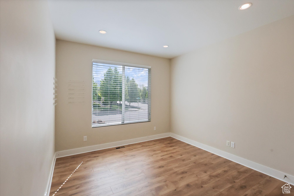 Unfurnished room with recessed lighting, wood finished floors, and visible vents
