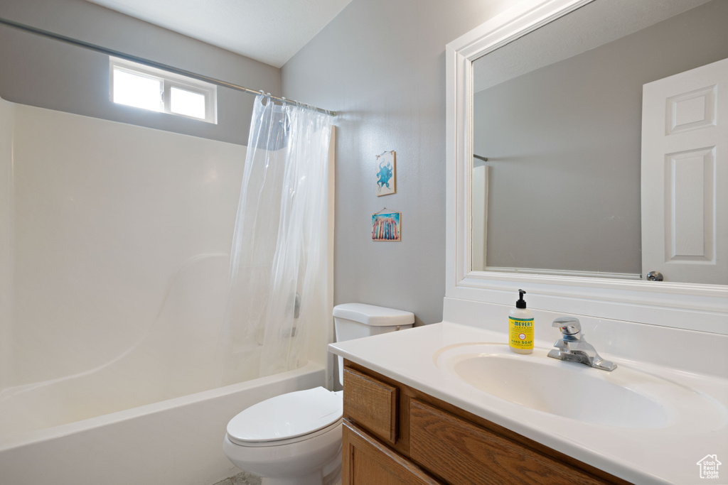 Full bath featuring vanity, shower / bath combination with curtain, and toilet