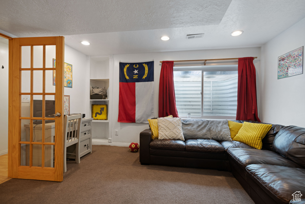Living room with visible vents, carpet flooring, a textured ceiling, and recessed lighting