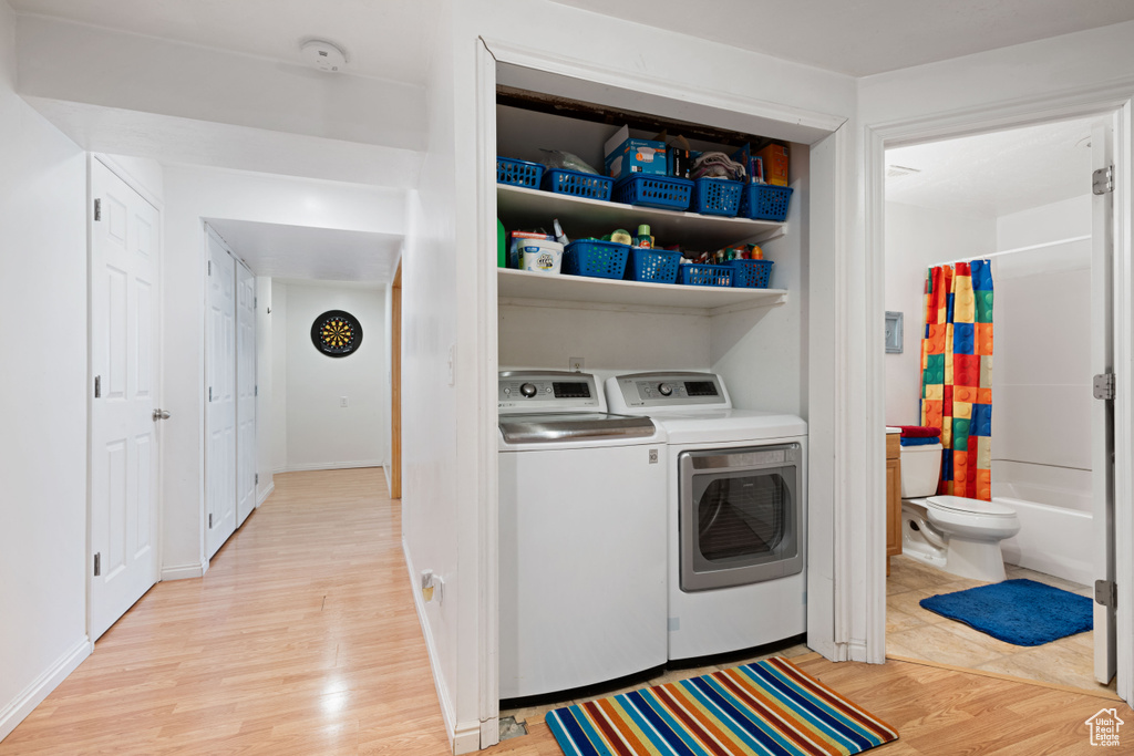 Laundry room with laundry area, light wood-style flooring, and washer and dryer
