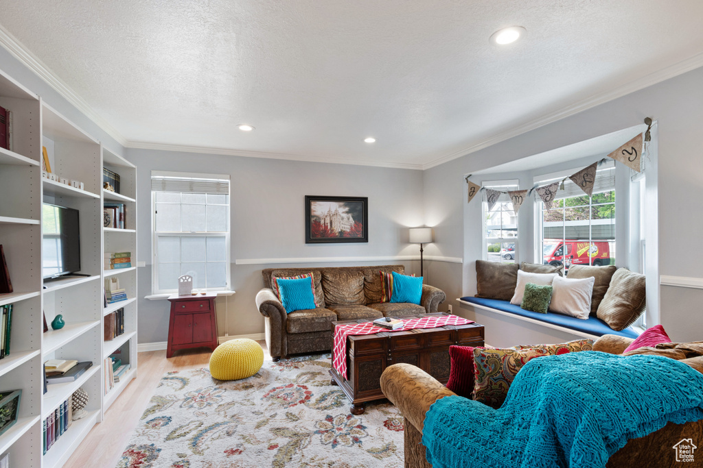 Living area featuring recessed lighting, ornamental molding, and wood finished floors