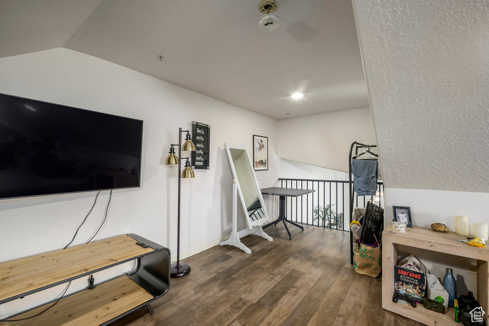 Workout area with wood finished floors and lofted ceiling