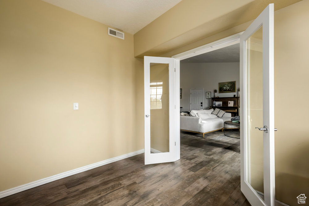 Interior space featuring visible vents, dark wood finished floors, baseboards, and french doors