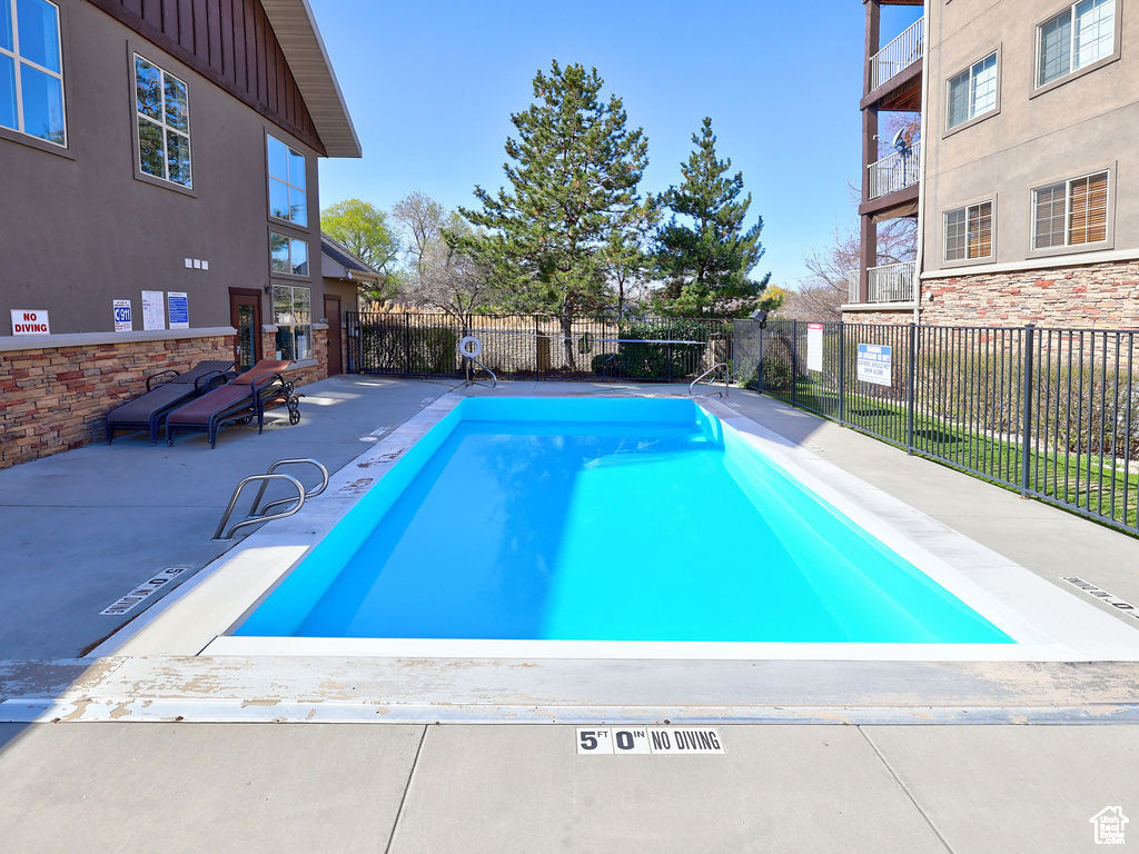 Pool featuring fence and a patio area