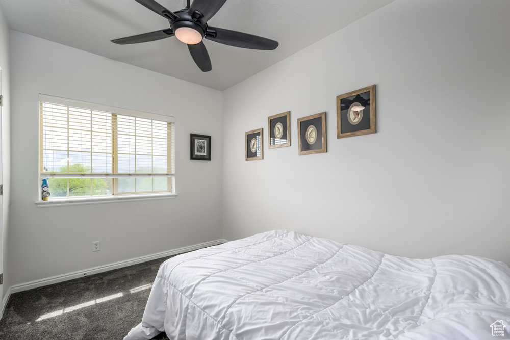 Bedroom with baseboards, ceiling fan, and carpet