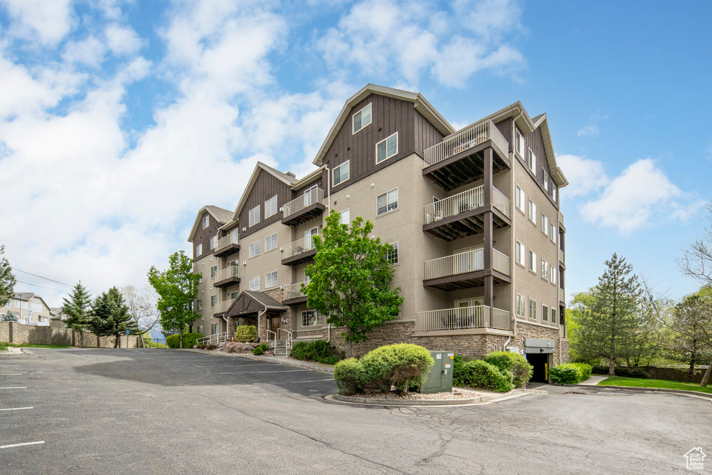 View of property with cooling unit and uncovered parking