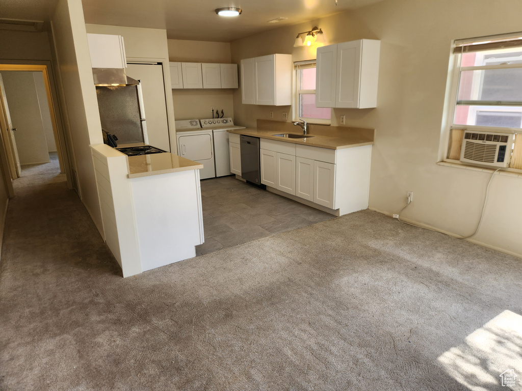 Kitchen featuring white cabinetry, washer and clothes dryer, carpet, stainless steel dishwasher, and a sink