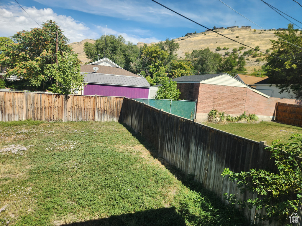 View of yard with a fenced backyard and a mountain view