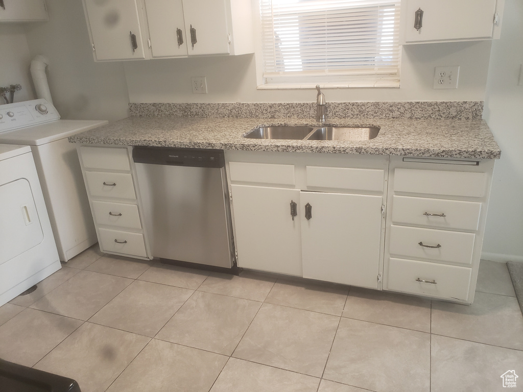 Kitchen featuring light tile patterned flooring, a sink, separate washer and dryer, dishwasher, and white cabinets