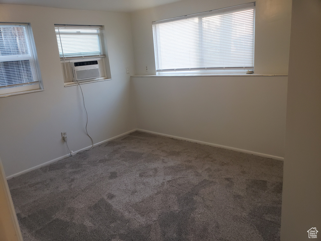 Carpeted spare room featuring baseboards
