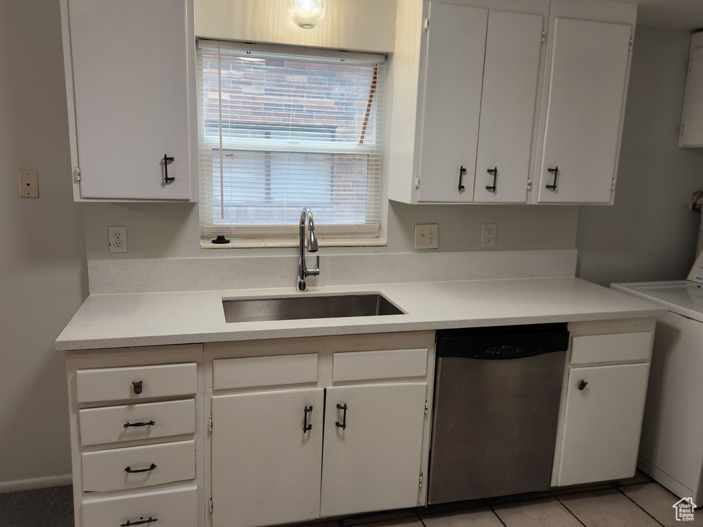 Kitchen with dishwasher, a sink, white cabinetry, and washer / dryer