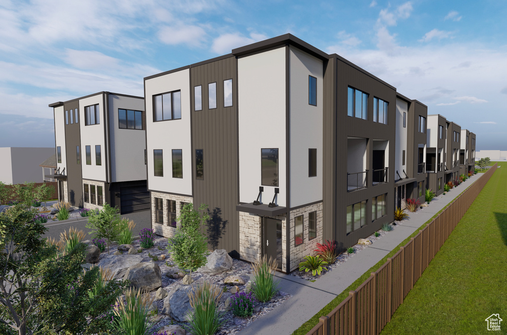 View of building exterior featuring fence, a residential view, and a garage