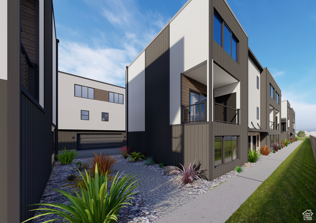 View of home's exterior featuring a garage, gravel driveway, and a balcony