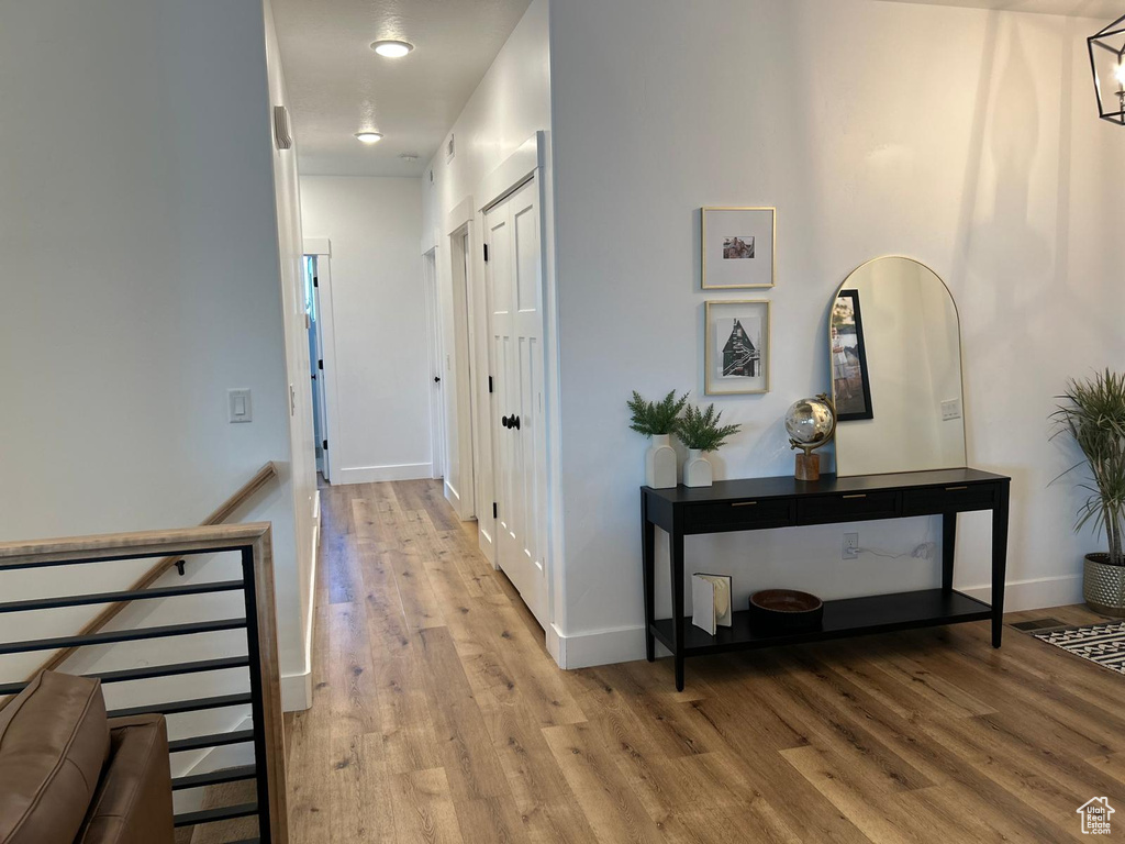 Hall with baseboards and light wood-style flooring