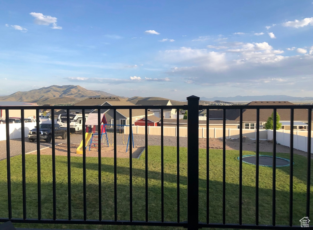 View of yard featuring fence, a mountain view, and playground community