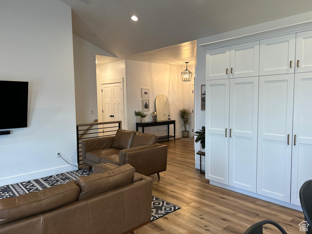 Living area with recessed lighting, baseboards, vaulted ceiling, and light wood-type flooring