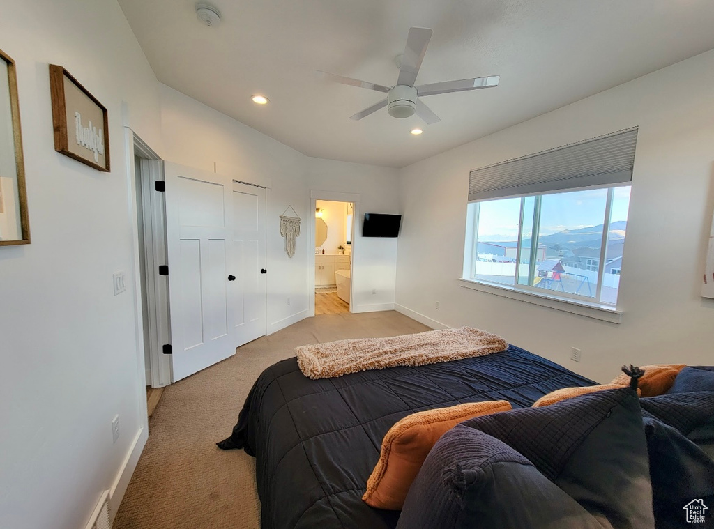 Bedroom featuring light colored carpet, recessed lighting, baseboards, a ceiling fan, and ensuite bathroom