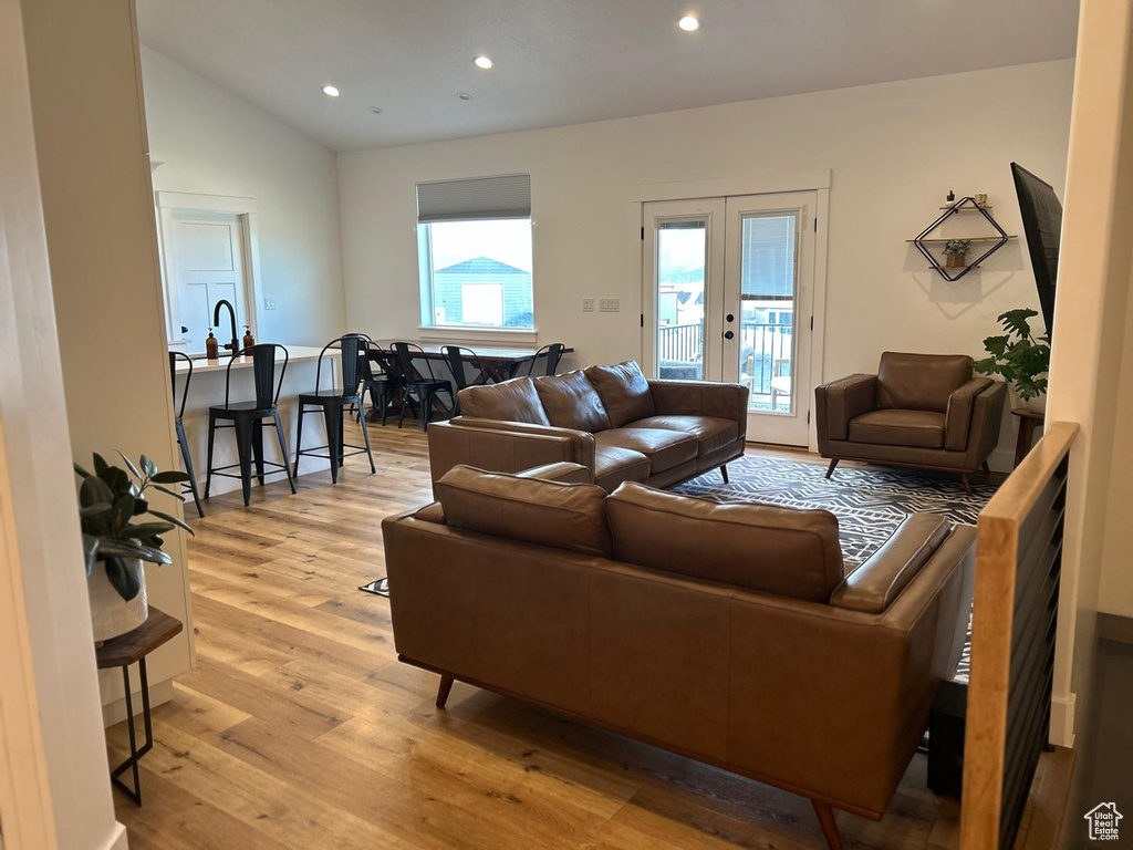 Living room featuring recessed lighting, lofted ceiling, french doors, and light wood finished floors