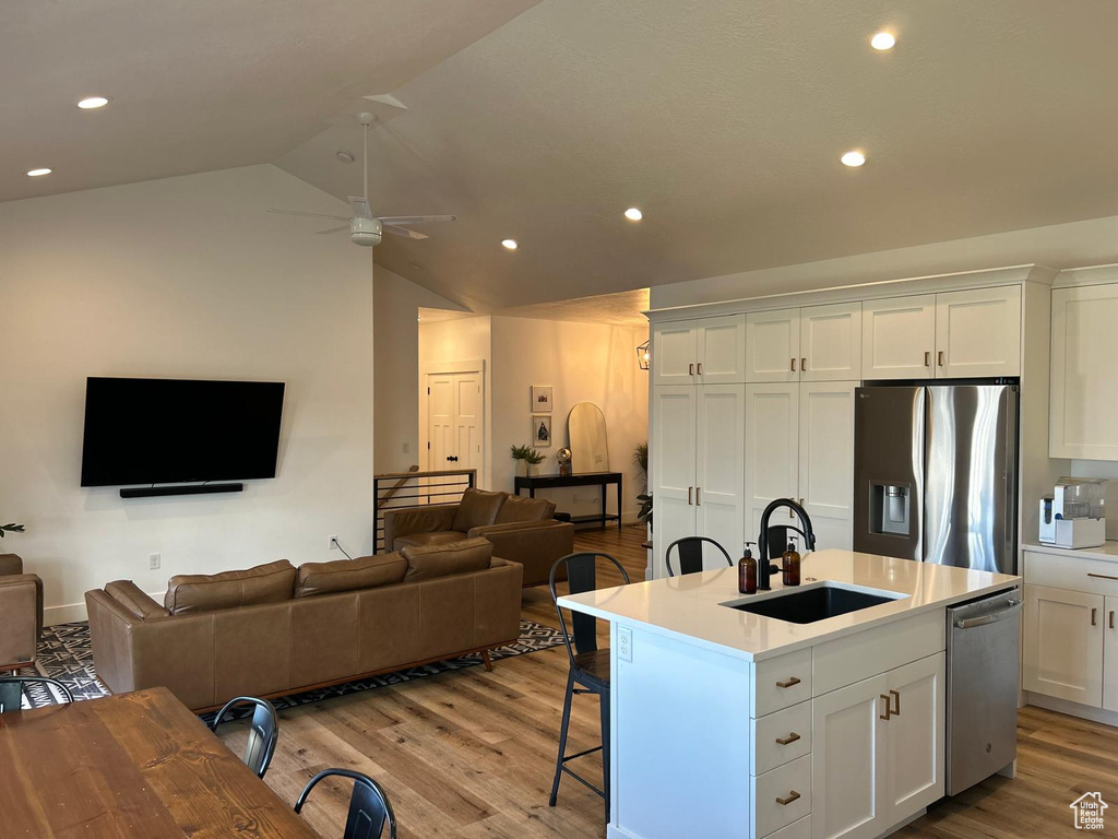 Kitchen featuring a ceiling fan, a sink, appliances with stainless steel finishes, and open floor plan