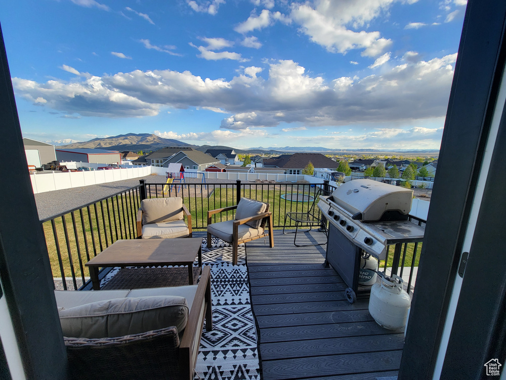 Wooden deck with a lawn, a mountain view, grilling area, and a residential view