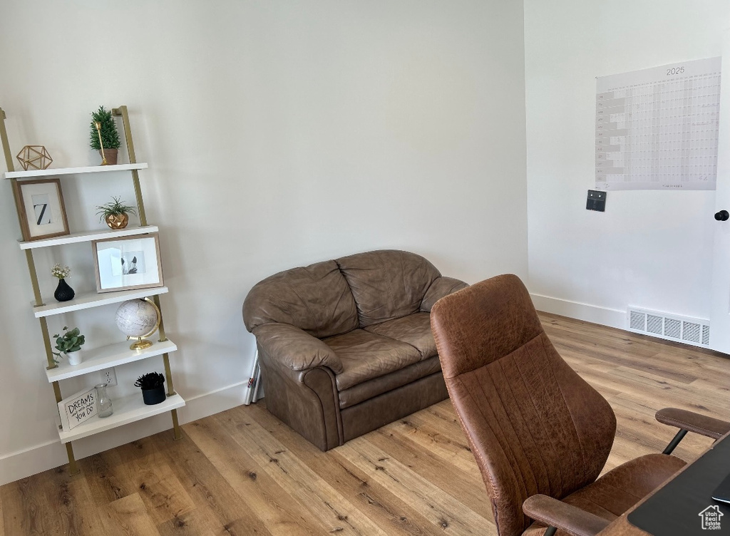 Living area featuring visible vents, baseboards, and wood finished floors