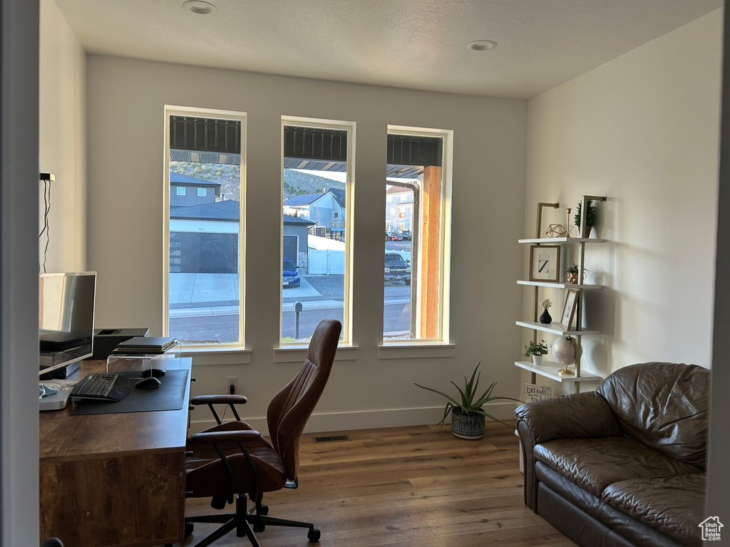 Office space featuring wood-type flooring and baseboards
