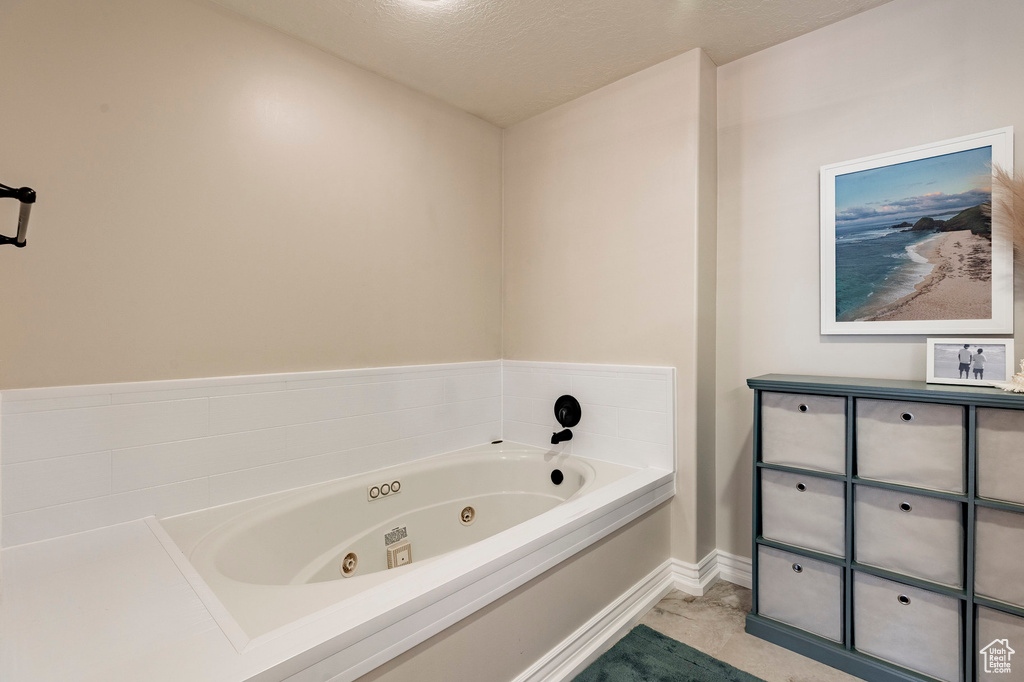 Full bath with baseboards and a tub with jets