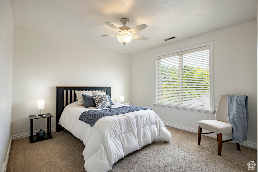 Bedroom with carpet flooring, baseboards, and a ceiling fan