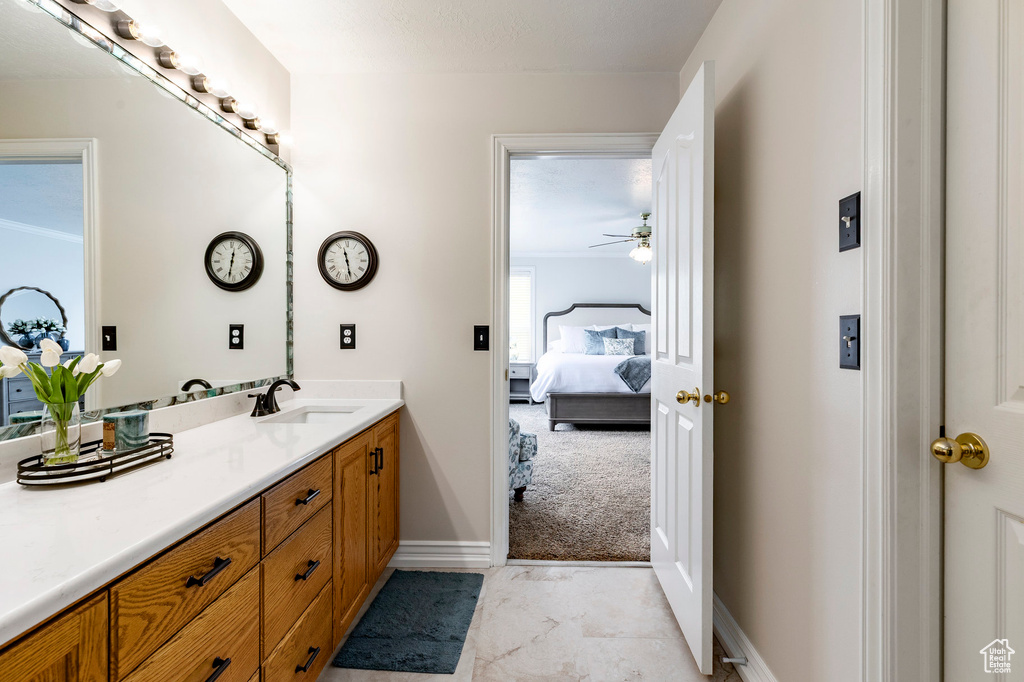 Bathroom featuring vanity, ensuite bathroom, baseboards, and ceiling fan