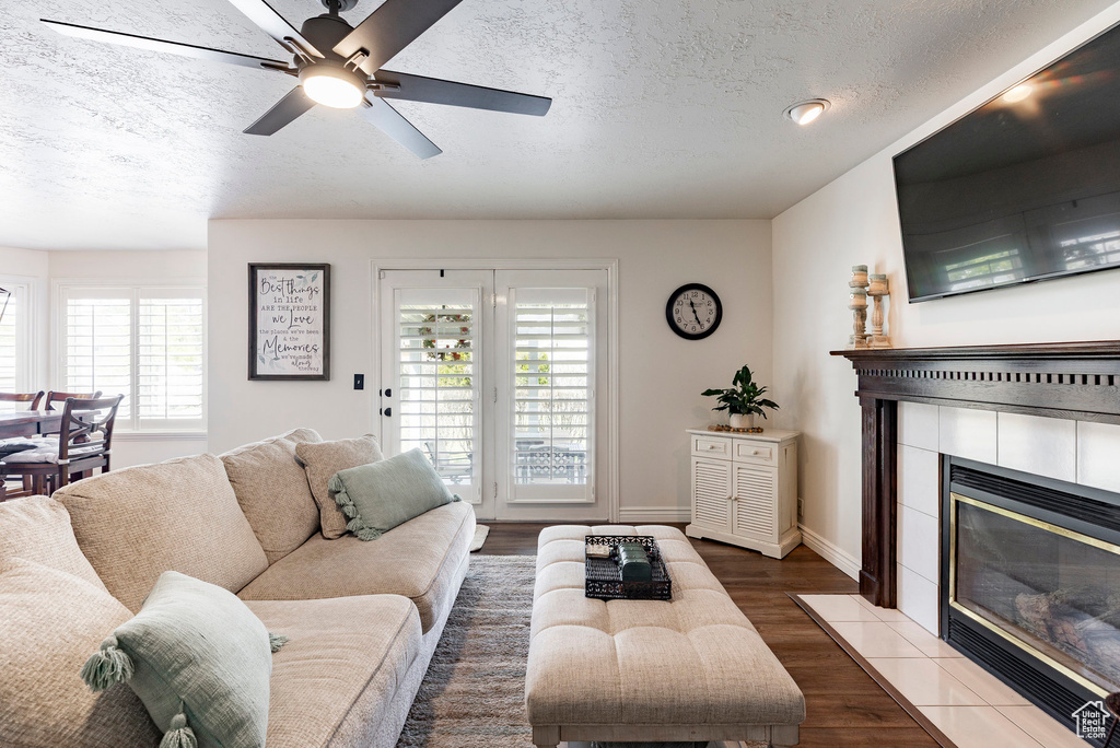 Living area with a textured ceiling, a healthy amount of sunlight, and a fireplace