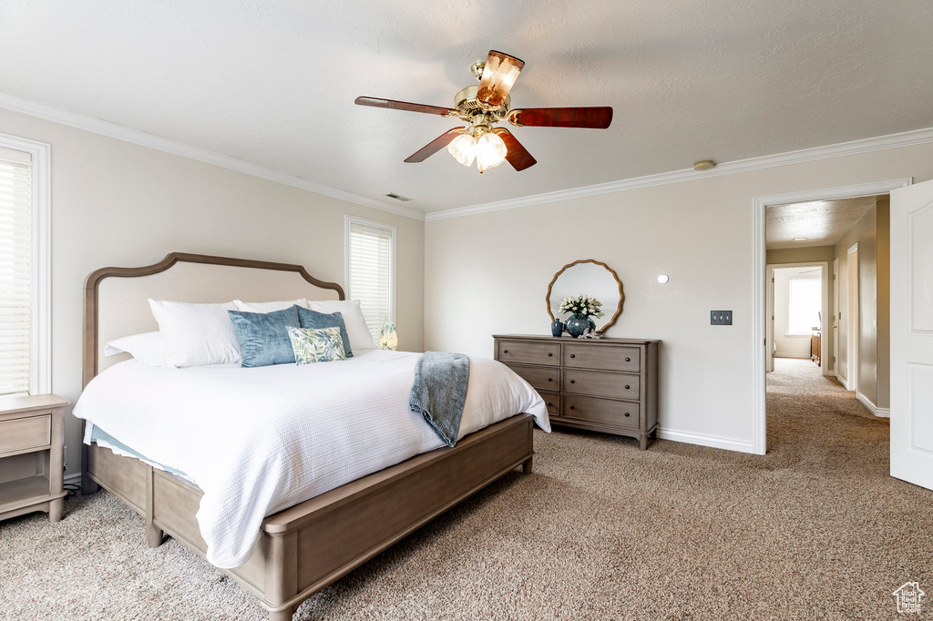 Bedroom featuring crown molding, baseboards, ceiling fan, and light carpet