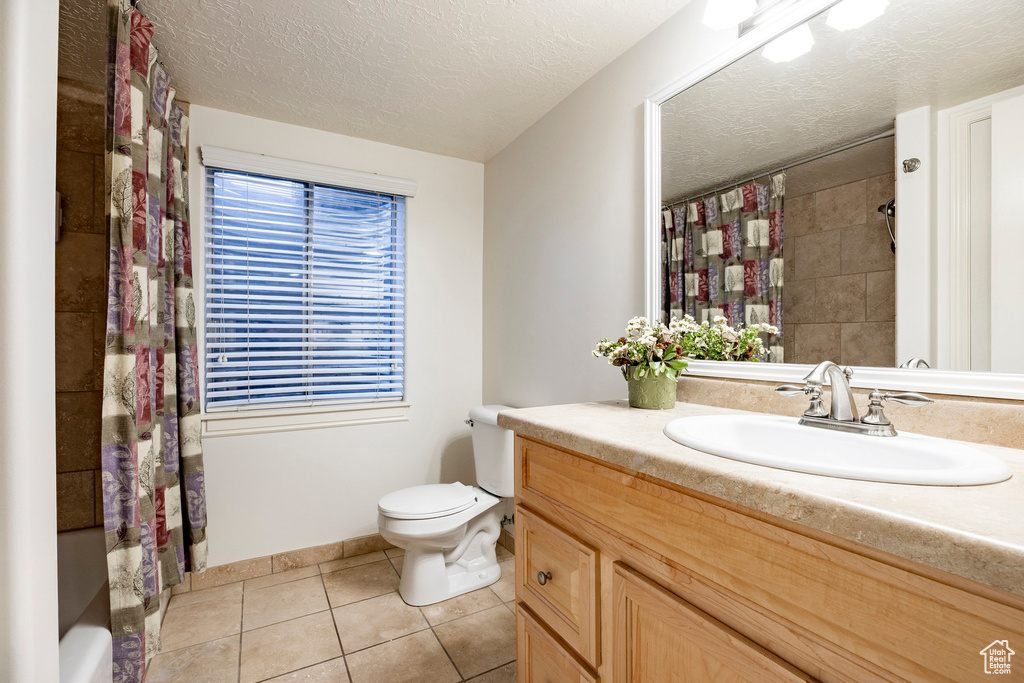Full bath featuring vanity, tile patterned flooring, a textured ceiling, toilet, and a shower with shower curtain