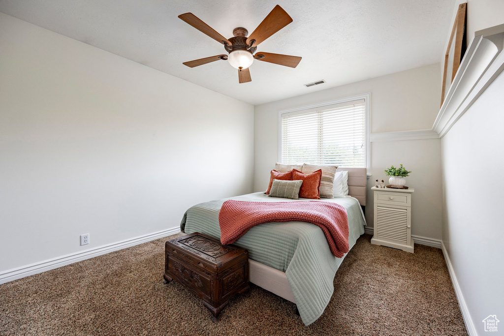 Carpeted bedroom featuring baseboards and a ceiling fan