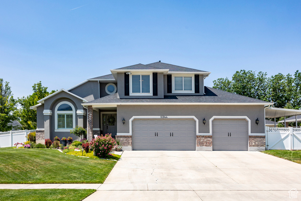 View of front of home featuring stucco siding, concrete driveway, brick siding, an attached garage, and roof with shingles