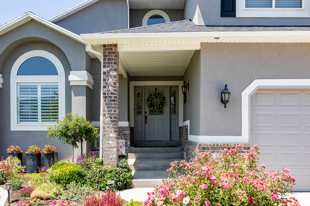 Doorway to property featuring stucco siding and stone siding