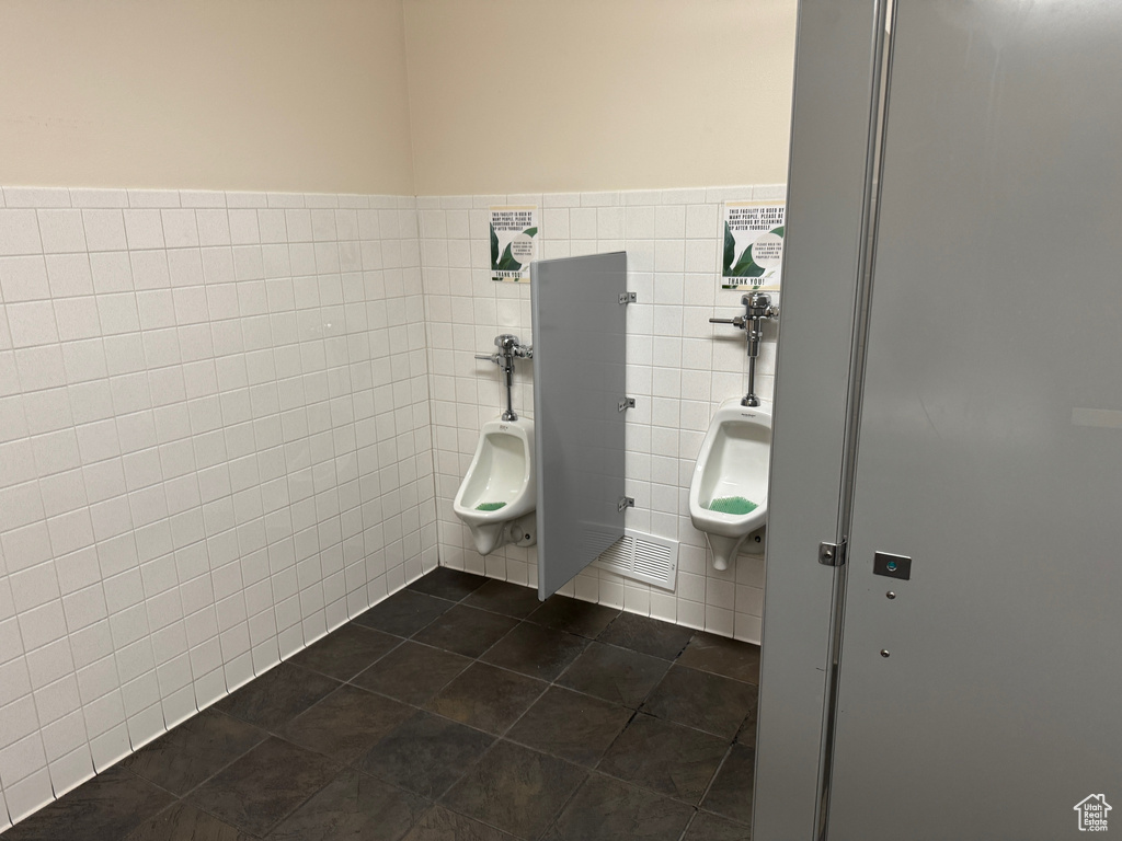 Bathroom with tile patterned flooring, visible vents, and tile walls