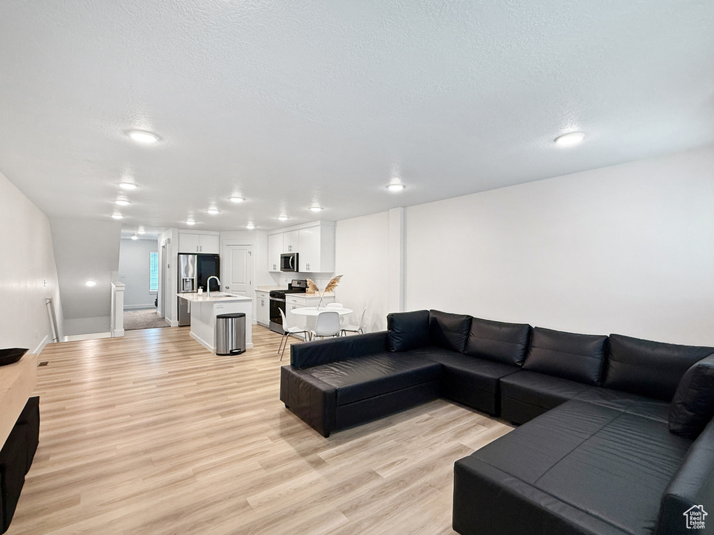 Living area with light wood-style floors and a textured ceiling