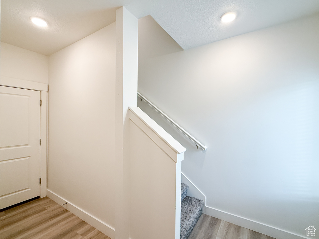 Stairs with baseboards, recessed lighting, and wood finished floors