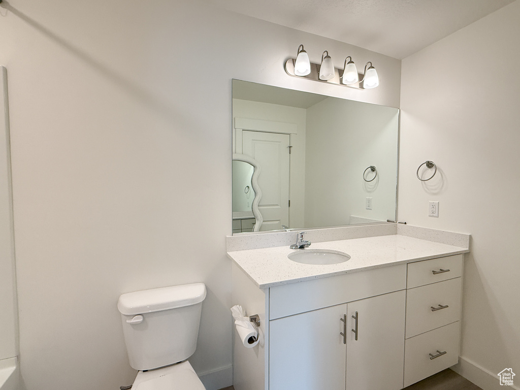 Bathroom with vanity, baseboards, and toilet